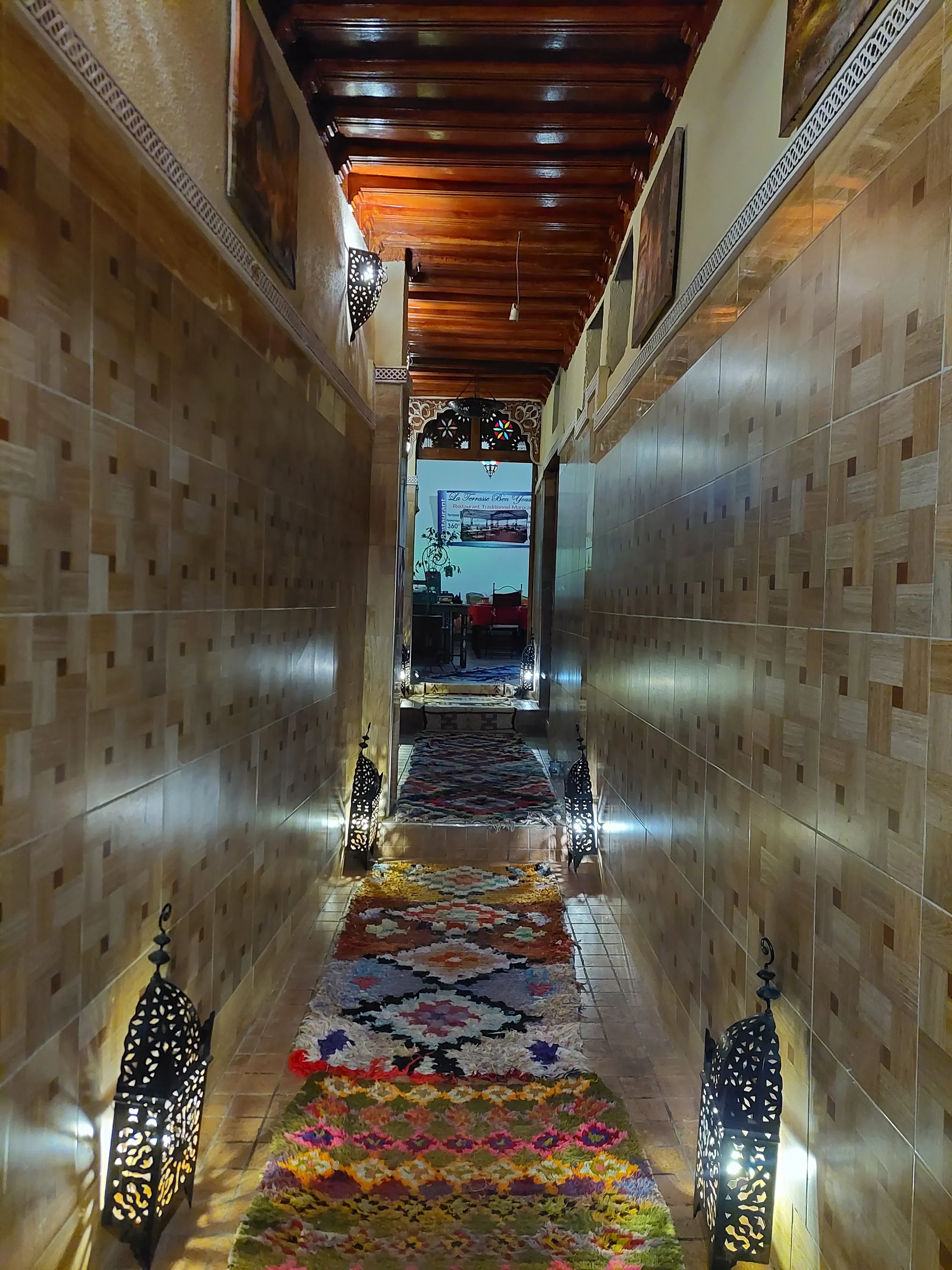 Narrow corridor lit by pierced-iron lanterns