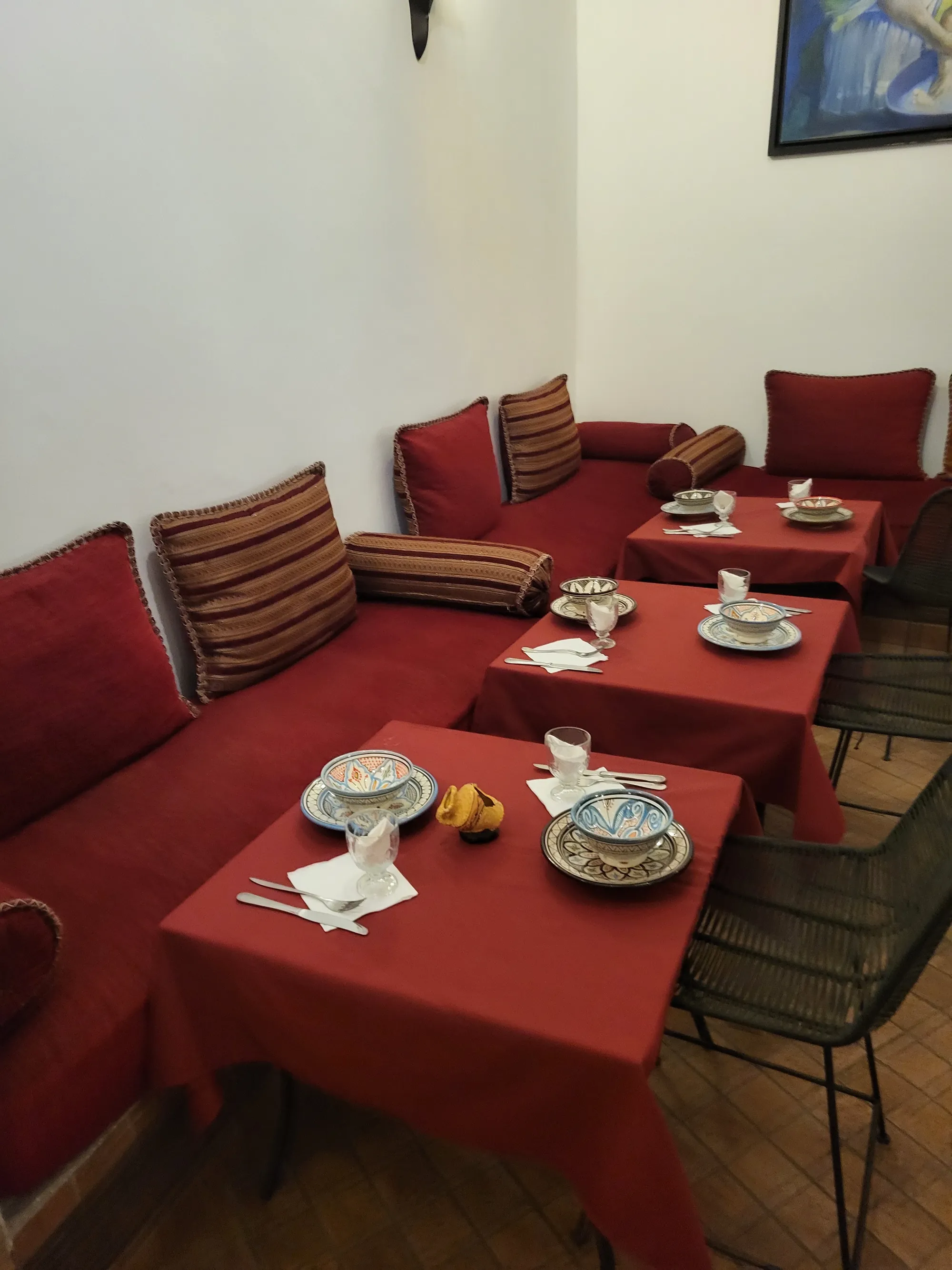 The Salle Rouge: low banquettes, red linen and carved plaster